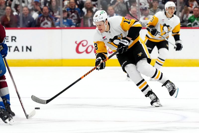 Mar 24, 2024; Denver, Colorado, USA; Pittsburgh Penguins right wing Jesse Puljujarvi (18) controls the puck in the first period against the Colorado Avalanche at Ball Arena. Mandatory Credit: Ron Chenoy-USA TODAY Sports