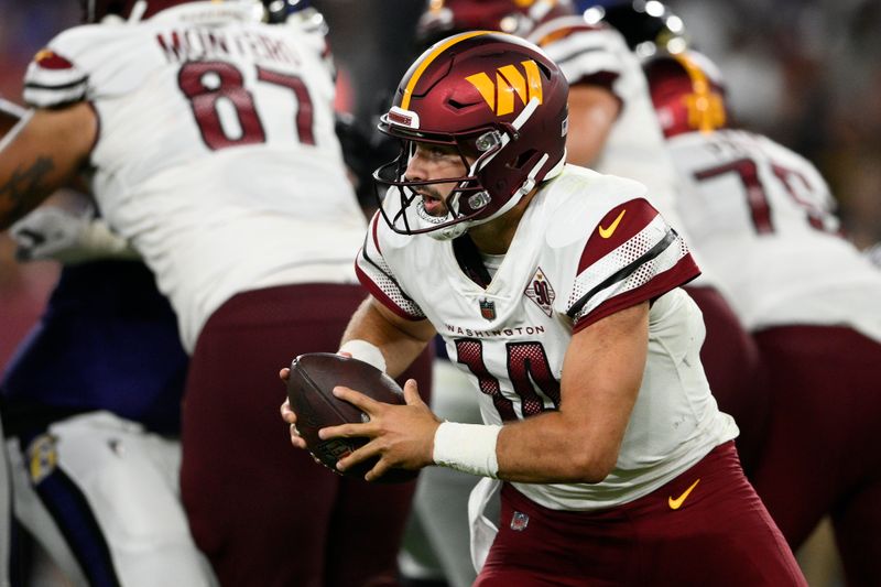 Washington Commanders quarterback Sam Howell (14) in action in the second half of a preseason NFL football game against the Baltimore Ravens, Saturday, Aug. 27, 2022, in Baltimore. (AP Photo/Nick Wass)