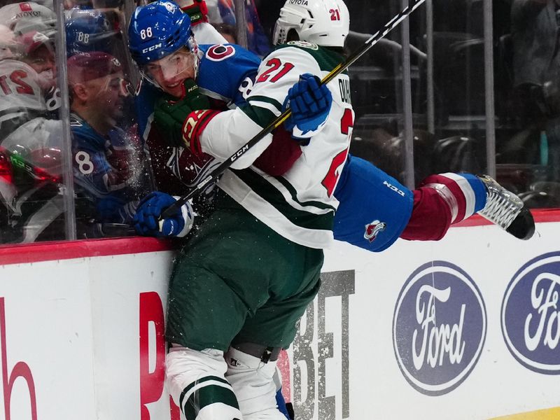 Sep 27, 2022; Denver, Colorado, USA; Minnesota Wild right wing Brandon Duhaime (21) checks Colorado Avalanche defenseman Andreas England (88) in the first period at Ball Arena. Mandatory Credit: Ron Chenoy-USA TODAY Sports