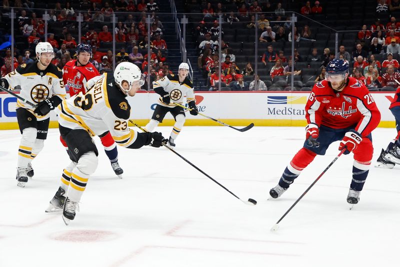 Oct 5, 2024; Washington, District of Columbia, USA; Boston Bruins right wing Fabian Lysell (23) clears the puck from Washington Capitals center Nic Dowd (26) in the first period at Capital One Arena. Mandatory Credit: Geoff Burke-Imagn Images