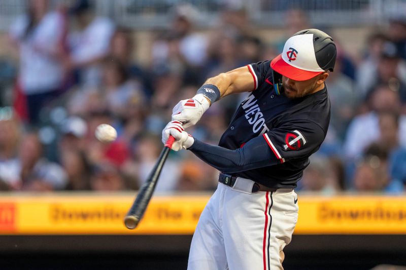 Jun 10, 2024; Minneapolis, Minnesota, USA; Minnesota Twins left fielder Trevor Larnach (9) hits a RBI fly ball against the Colorado Rockies in the eighth inning at Target Field. Mandatory Credit: Jesse Johnson-USA TODAY Sports