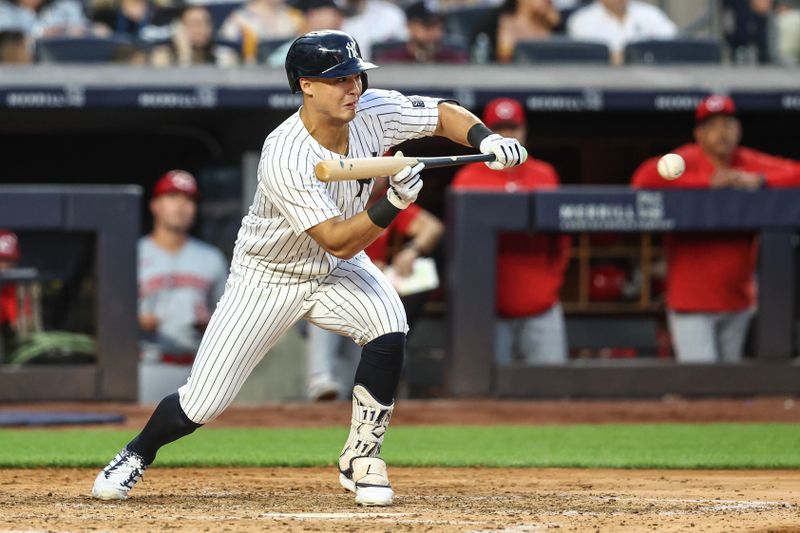 Jul 3, 2024; Bronx, New York, USA; New York Yankees shortstop Anthony Volpe (11) attempts to bunt for a base hit in the fifth inning against the Cincinnati Reds at Yankee Stadium. Mandatory Credit: Wendell Cruz-USA TODAY Sports