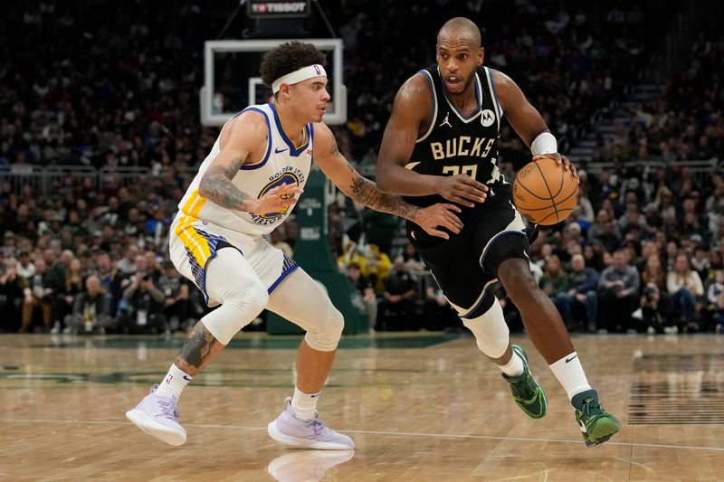 MILWAUKEE, WISCONSIN - JANUARY 13: Khris Middleton #22 of the Milwaukee Bucks dribbles the ball against Lester Quinones #25 of the Golden State Warriors in the second half at Fiserv Forum on January 13, 2024 in Milwaukee, Wisconsin. NOTE TO USER: User expressly acknowledges and agrees that, by downloading and or using this photograph, User is consenting to the terms and conditions of the Getty Images License Agreement. (Photo by Patrick McDermott/Getty Images)