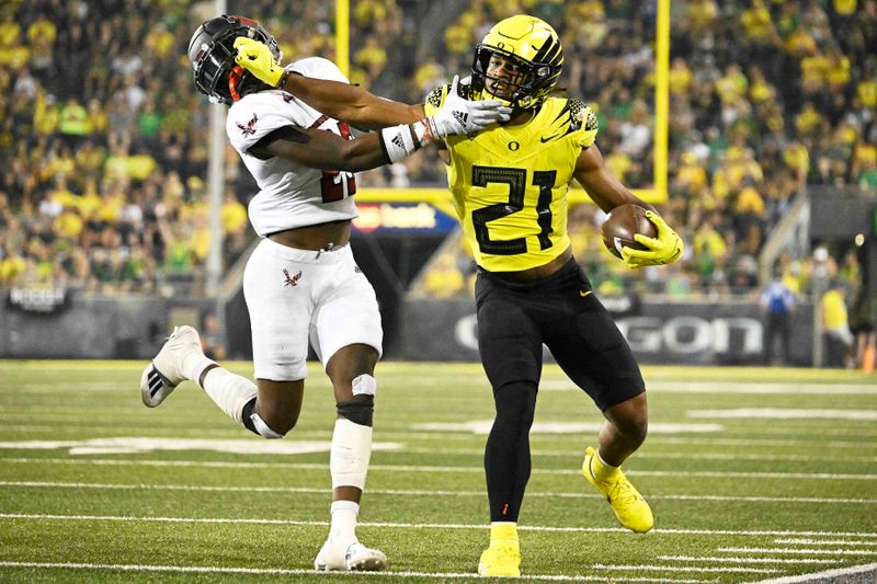 Sep 10, 2022; Eugene, Oregon, USA; Oregon Ducks running back Byron Cardwell (21) stiff arms Eastern Washington Eagles defensive back Ely Doyle (25) during the second half at Autzen Stadium. The Ducks won 70-14. Mandatory Credit: Troy Wayrynen-USA TODAY Sports