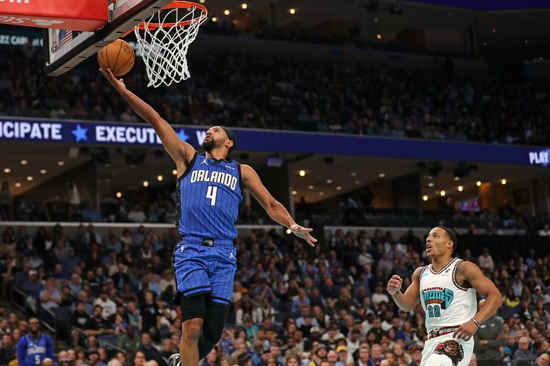 MEMPHIS, TENNESSEE - OCTOBER 26: Jalen Suggs #4 of the Orlando Magic goes to the basket against Desmond Bane #22 of the Memphis Grizzlies during the first half at FedExForum on October 26, 2024 in Memphis, Tennessee. NOTE TO USER: User expressly acknowledges and agrees that, by downloading and or using this photograph, User is consenting to the terms and conditions of the Getty Images License Agreement. (Photo by Justin Ford/Getty Images)