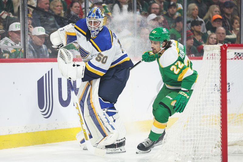 Mar 23, 2024; Saint Paul, Minnesota, USA; St. Louis Blues goaltender Jordan Binnington (50) passes as Minnesota Wild center Marat Khusnutdinov (22) defends during the first period at Xcel Energy Center. Mandatory Credit: Matt Krohn-USA TODAY Sports