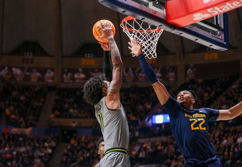 Feb 17, 2024; Morgantown, West Virginia, USA; Baylor Bears forward Jalen Bridges (11) dunks the ball over West Virginia Mountaineers forward Josiah Harris (22) during the first half at WVU Coliseum. Mandatory Credit: Ben Queen-USA TODAY Sports