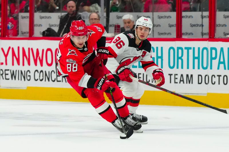 May 11, 2023; Raleigh, North Carolina, USA; Carolina Hurricanes center Martin Necas (88) skates with the puck past New Jersey Devils center Jack Hughes (86) during the first period in game five of the second round of the 2023 Stanley Cup Playoffs at PNC Arena. Mandatory Credit: James Guillory-USA TODAY Sports