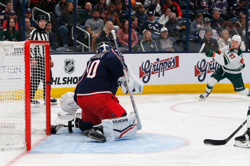 Oct 19, 2024; Columbus, Ohio, USA; Minnesota Wild left wing Kirill Kaprizov (97) shots sails past Columbus Blue Jackets goalie Daniil Tarasov (40) for a goal during the third period  at Nationwide Arena. Mandatory Credit: Russell LaBounty-Imagn Images