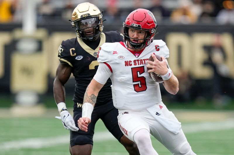 Nov 11, 2023; Winston-Salem, North Carolina, USA;  North Carolina State Wolfpack quarterback Brennan Armstrong (5) tries to outrun Wake Forest Demon Deacons defensive back Malik Mustapha (3) during the first half at Allegacy Federal Credit Union Stadium. Mandatory Credit: Jim Dedmon-USA TODAY Sports