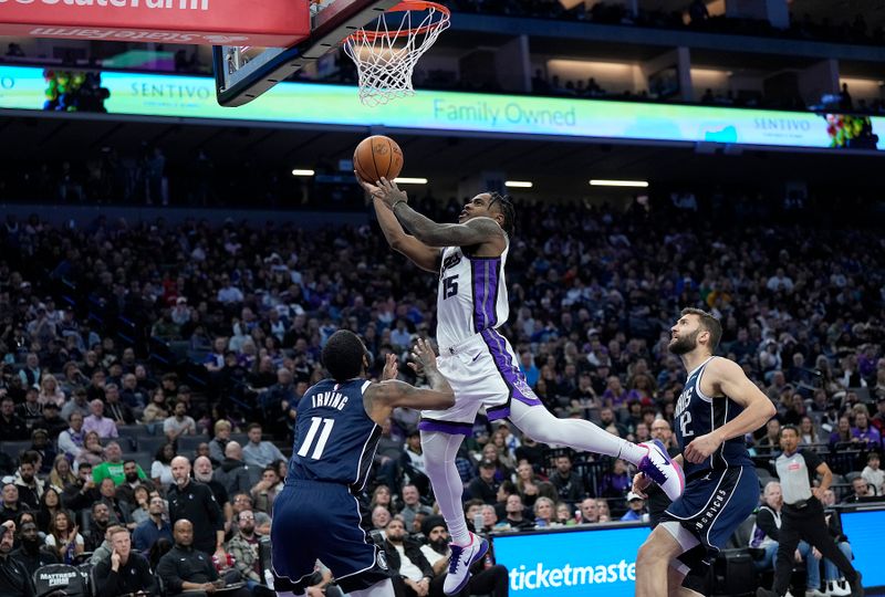 SACRAMENTO, CALIFORNIA - MARCH 29: Davion Mitchell #15 of the Sacramento Kings shoots and scores over Kyrie Irving #11 of the Dallas Mavericks during the second half at Golden 1 Center on March 29, 2024 in Sacramento, California. NOTE TO USER: User expressly acknowledges and agrees that, by downloading and or using this photograph, User is consenting to the terms and conditions of the Getty Images License Agreement. (Photo by Thearon W. Henderson/Getty Images)