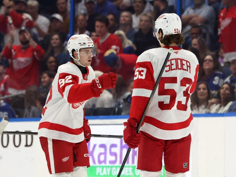 Apr 11, 2025; Tampa, Florida, USA; Detroit Red Wings center Marco Kasper (92) is congratulated by defenseman Moritz Seider (53) after he scored a goal against the Tampa Bay Lightning during the third period at Amalie Arena. Mandatory Credit: Kim Klement Neitzel-Imagn Images