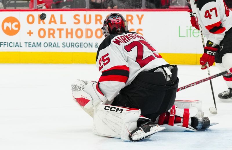 Oct 15, 2024; Raleigh, North Carolina, USA;  New Jersey Devils goaltender Jacob Markstrom (25) makes save against the Carolina Hurricanes during the third period at PNC Arena. Mandatory Credit: James Guillory-Imagn Images