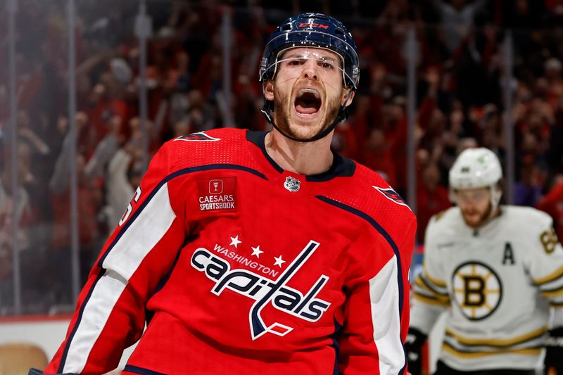 Apr 15, 2024; Washington, District of Columbia, USA; Washington Capitals center Nic Dowd (26) celebrates after scoring an empty net goal as Boston Bruins right wing David Pastrnak (88) looks on in the final minute of the third period at Capital One Arena. Mandatory Credit: Geoff Burke-USA TODAY Sports