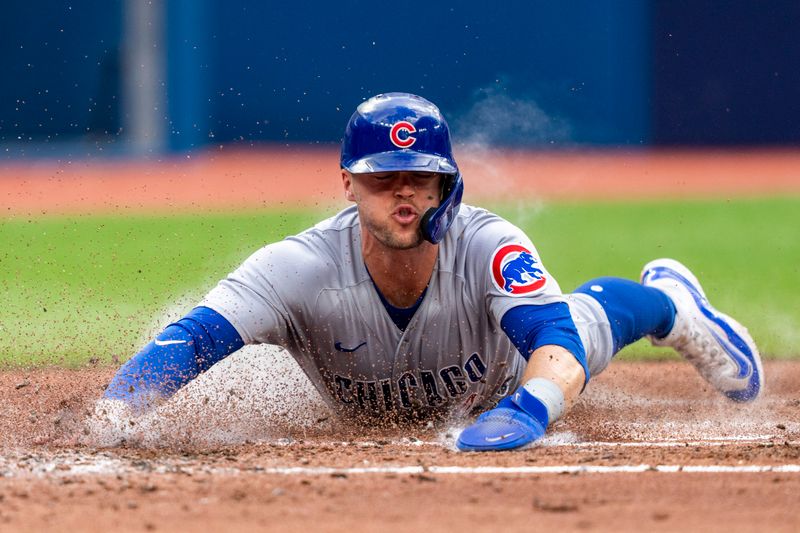 Aug 12, 2023; Toronto, Ontario, CAN;  Chicago Cubs second baseman Nico Hoerner (2) slides into home-plate to score against the Toronto Blue Jays during the fourth inning at Rogers Centre. Mandatory Credit: Kevin Sousa-USA TODAY Sports