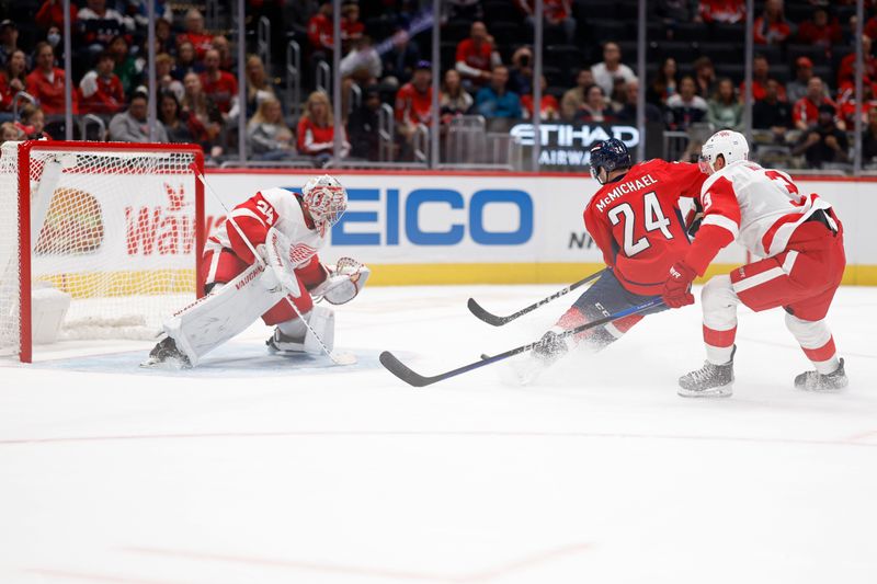 Sep 28, 2023; Washington, District of Columbia, USA; Washington Capitals center Connor McMichael (24) skates in on Detroit Red Wings goaltender Alex Lyon (34) as Red Wings defenseman Justin Holl (3) defends in the first period at Capital One Arena. Mandatory Credit: Geoff Burke-USA TODAY Sports