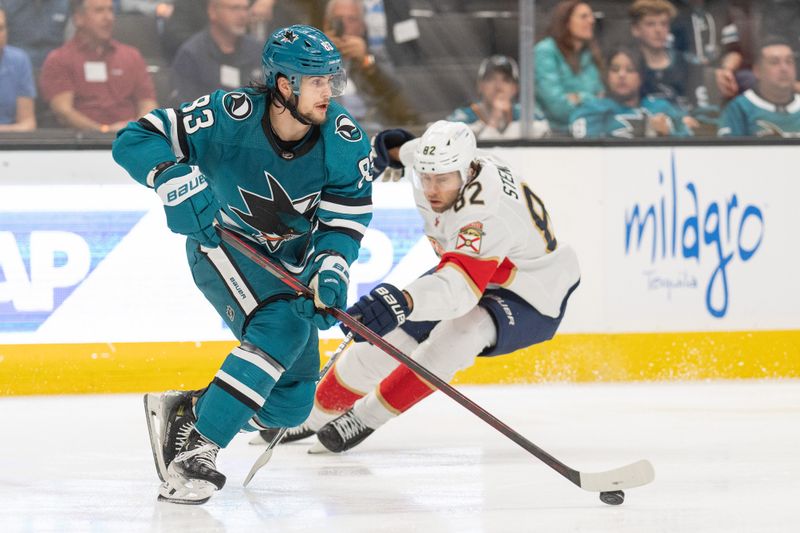 Nov 14, 2023; San Jose, California, USA; San Jose Sharks defenseman Nikita Okhotiuk (83) controls the puck against Florida Panthers center Kevin Stenlund (82) during the first period at SAP Center at San Jose. Mandatory Credit: Stan Szeto-USA TODAY Sports
