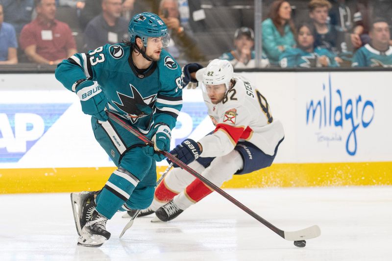 Nov 14, 2023; San Jose, California, USA; San Jose Sharks defenseman Nikita Okhotiuk (83) controls the puck against Florida Panthers center Kevin Stenlund (82) during the first period at SAP Center at San Jose. Mandatory Credit: Stan Szeto-USA TODAY Sports