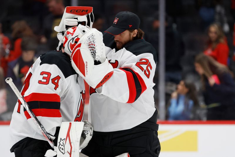 Nov 23, 2024; Washington, District of Columbia, USA; New Jersey Devils goaltender Jake Allen (34) celebrates with Devils goaltender Jacob Markstrom (25) after their game against the Washington Capitals at Capital One Arena. Mandatory Credit: Geoff Burke-Imagn Images