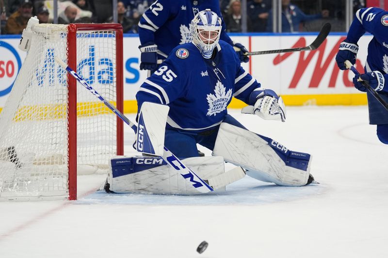 Nov 9, 2025; Toronto, Ontario, CAN; Toronto Maple Leafs goaltender Dennis Hildeby (35) deflects a Carolina Hurricanes shot away from the net during the second period at Scotiabank Arena. Mandatory Credit: John E. Sokolowski-Imagn Images