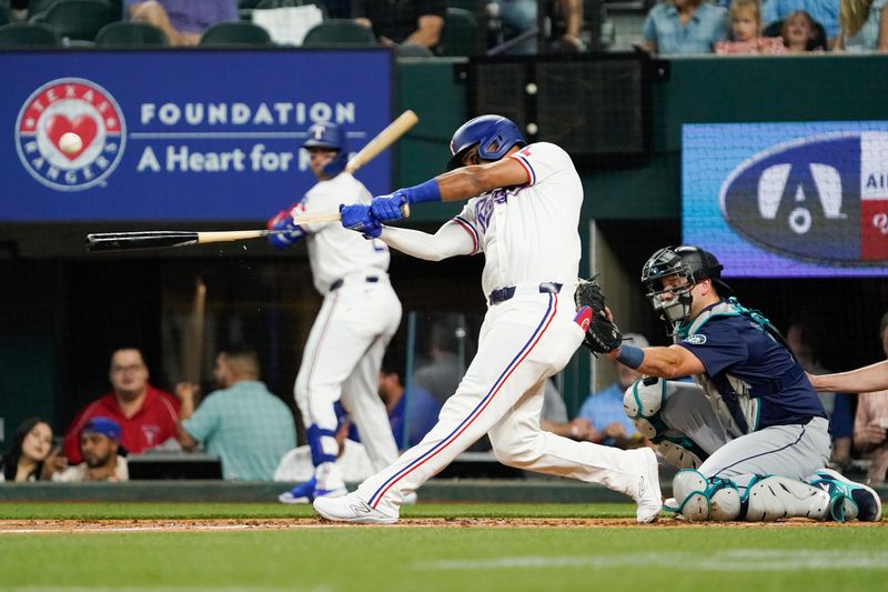 Apr 25, 2024; Arlington, Texas, USA; Texas Rangers third baseman Ezequiel Duran (20) breaks his bat as he makes contact with the ball during the second inning against the Seattle Mariners at Globe Life Field. Mandatory Credit: Raymond Carlin III-USA TODAY Sports