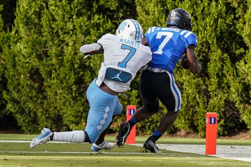 Nov 7, 2020; Durham, North Carolina, USA; Duke Blue Devils running back Jordan Waters (7) goes in for a touchdown past North Carolina Tar Heels linebacker Eugene Asante (7) during the second half at Wallace Wade Stadium. Mandatory Credit: Jim Dedmon-USA TODAY Sports