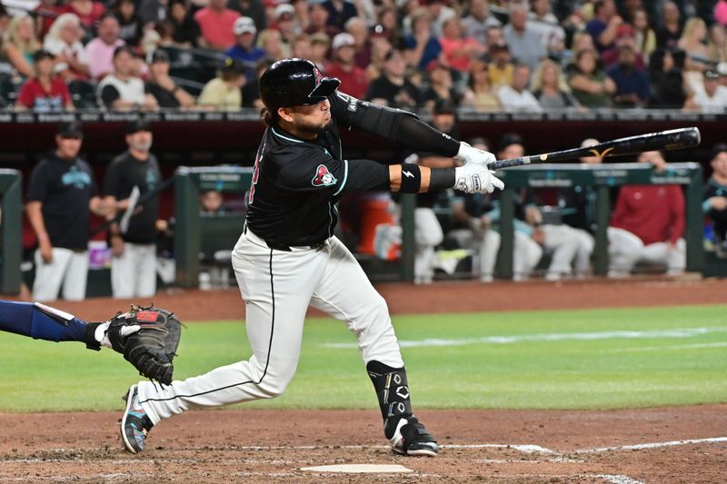 Jul 10, 2024; Phoenix, Arizona, USA;  Arizona Diamondbacks third base Eugenio Suárez (28) hits a RBI double in the seventh inning against the Atlanta Braves at Chase Field. Mandatory Credit: Matt Kartozian-USA TODAY Sports