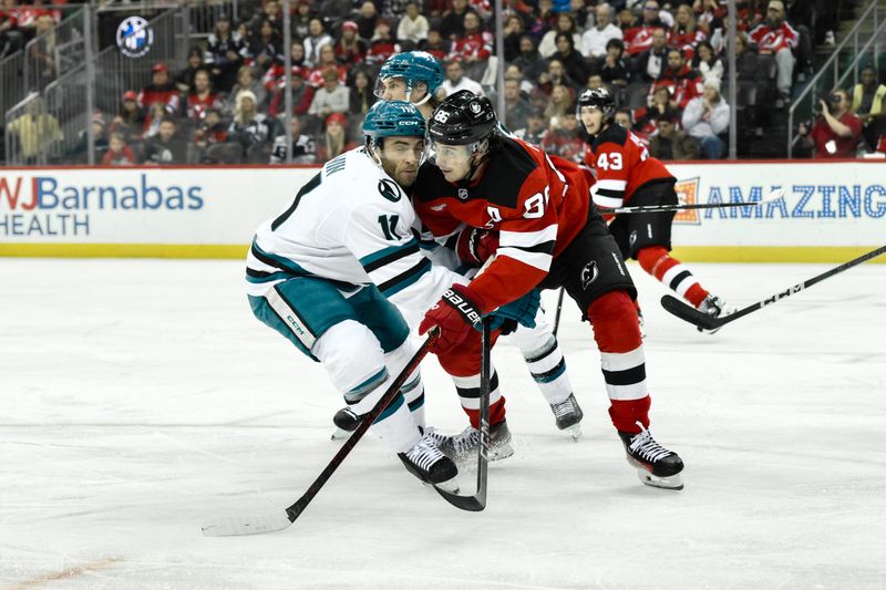 Nov 10, 2024; Newark, New Jersey, USA; New Jersey Devils center Jack Hughes (86) tries to skate past San Jose Sharks center Luke Kunin (11) during the second period at Prudential Center. Mandatory Credit: John Jones-Imagn Images