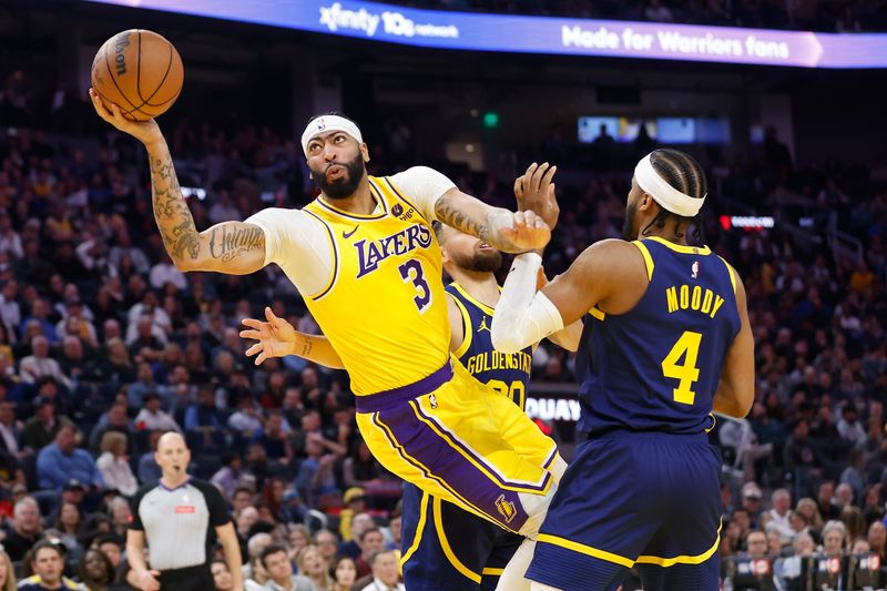 SAN FRANCISCO, CALIFORNIA - FEBRUARY 22: Anthony Davis #3 of the Los Angeles Lakers goes to the basket against Stephen Curry #30 and Moses Moody #4 of the Golden State Warriors in the first half at Chase Center on February 22, 2024 in San Francisco, California. NOTE TO USER: User expressly acknowledges and agrees that, by downloading and or using this photograph, User is consenting to the terms and conditions of the Getty Images License Agreement. (Photo by Lachlan Cunningham/Getty Images)