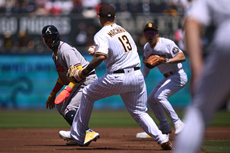 Apr 19, 2023; San Diego, California, USA; Atlanta Braves right fielder Ronald Acuna (left) is caught in a rundown by San Diego Padres third baseman Manny Machado (13) during the first inning at Petco Park. Mandatory Credit: Orlando Ramirez-USA TODAY Sports