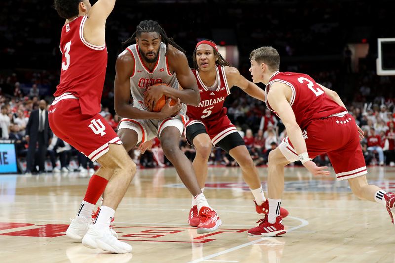 Feb 6, 2024; Columbus, Ohio, USA; Ohio State Buckeyes guard Evan Mahaffey (12) controls the ball as Indiana Hoosiers guard Anthony Leal (3) and guard Gabe Cupps (2) and forward Malik Reneau (5) defend during the second half at Value City Arena. Mandatory Credit: Joseph Maiorana-USA TODAY Sports