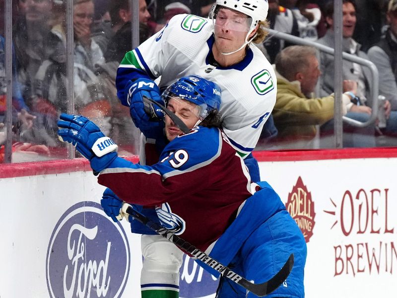 Feb 20, 2024; Denver, Colorado, USA; Colorado Avalanche defenseman Samuel Girard (49) checks Vancouver Canucks right wing Brock Boeser (6) in the first period at Ball Arena. Mandatory Credit: Ron Chenoy-USA TODAY Sports