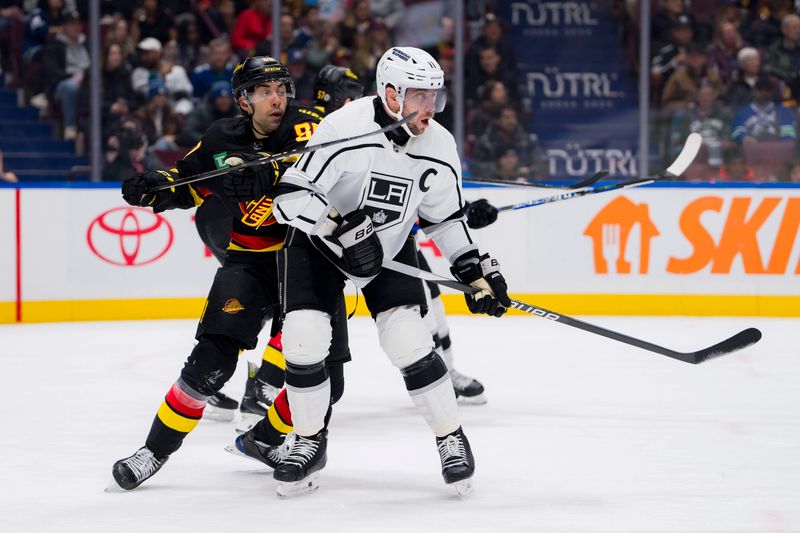 Feb 29, 2024; Vancouver, British Columbia, CAN; Vancouver Canucks forward Arshdeep Bains (80) battles with Los Angeles Kings forward Anze Kopitar (11) in the first period at Rogers Arena. Mandatory Credit: Bob Frid-USA TODAY Sports