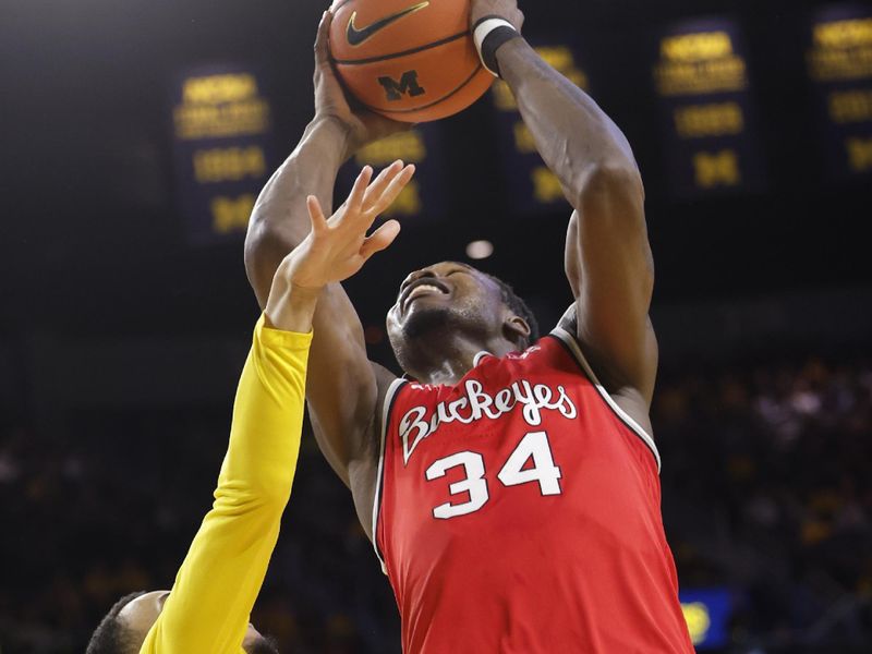 Jan 15, 2024; Ann Arbor, Michigan, USA; Ohio State Buckeyes center Felix Okpara (34) shoots over Michigan Wolverines guard Jaelin Llewellyn (3) in the second half  at Crisler Center. Mandatory Credit: Rick Osentoski-USA TODAY Sports