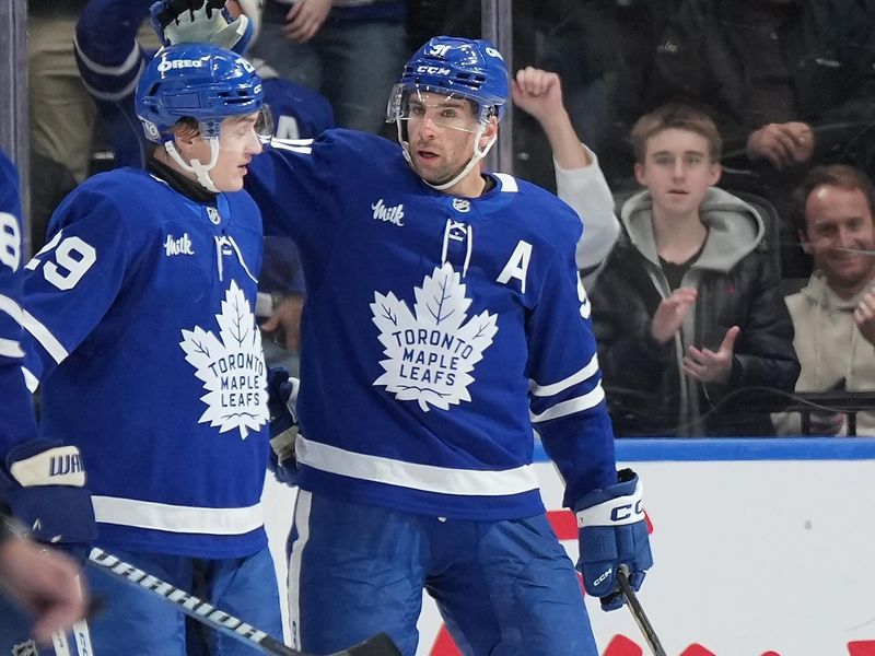 Dec 6, 2024; Toronto, Ontario, CAN; Toronto Maple Leafs center John Tavares (91) scores a gaol and with right wing Pontus Holmberg (29) against the Washington Capitals during the second period at Scotiabank Arena. Mandatory Credit: Nick Turchiaro-Imagn Images