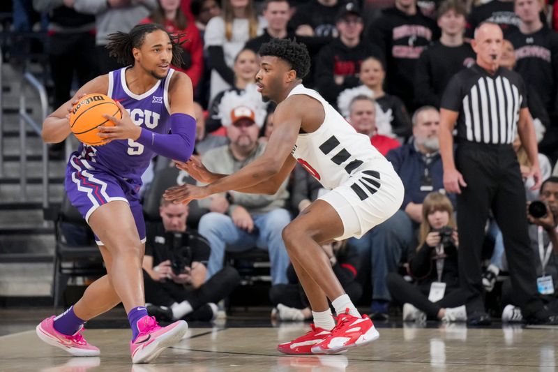 Jan 16, 2024; Cincinnati, Ohio, USA;  TCU Horned Frogs forward Chuck O'Bannon Jr. (5) controls the ball against Cincinnati Bearcats guard Josh Reed (10) in the first half at Fifth Third Arena. Mandatory Credit: Aaron Doster-USA TODAY Sports