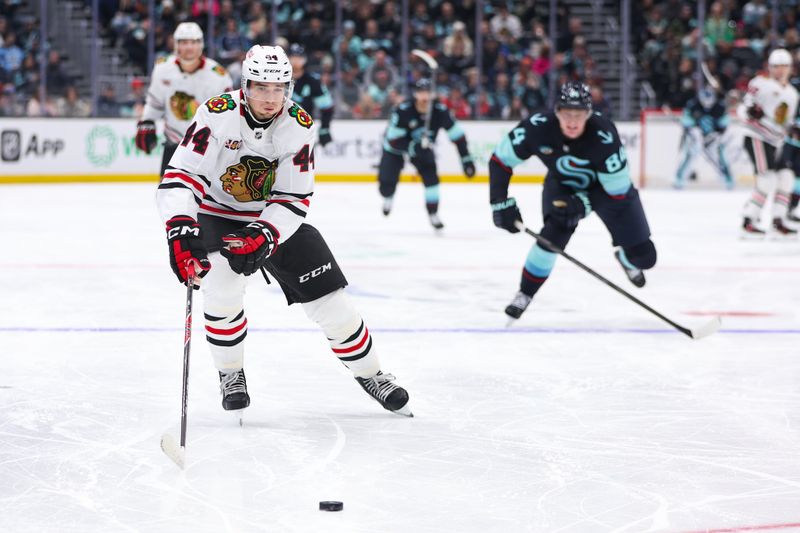 Nov 3, 2025; Seattle, Washington, USA; Chicago Blackhawks defenseman Wyatt Kaiser (44) goes for the puck in the second period against the Seattle Kraken at Climate Pledge Arena. Mandatory Credit: Kevin Ng-Imagn Images