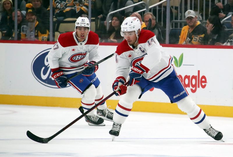 Nov 2, 2024; Pittsburgh, Pennsylvania, USA;  Montreal Canadiens center Nick Suzuki (14) passes the puck against the Pittsburgh Penguins during the second period at PPG Paints Arena. Mandatory Credit: Charles LeClaire-Imagn Images