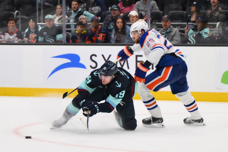 Mar 2, 2024; Seattle, Washington, USA; Seattle Kraken left wing Jared McCann (19) and Edmonton Oilers center Leon Draisaitl (29) play the puck during the third period at Climate Pledge Arena. Mandatory Credit: Steven Bisig-USA TODAY Sports