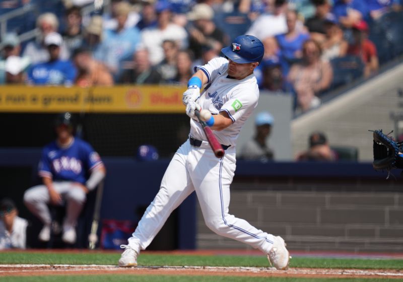 Jul 27, 2024; Toronto, Ontario, CAN; Toronto Blue Jays outfielder Daulton Varsho (25) hits a three run home run against the Texas Rangers during the first inning at Rogers Centre. Mandatory Credit: Nick Turchiaro-USA TODAY Sports