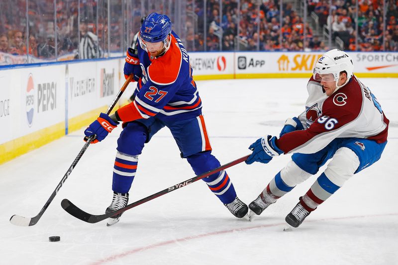 Mar 16, 2024; Edmonton, Alberta, CAN; Edmonton Oilers defensemen Brett Kulak (27)  and Colorado Avalanche forward Mikko Rantanen (96) battle for a loose puck during the third period at Rogers Place. Mandatory Credit: Perry Nelson-USA TODAY Sports