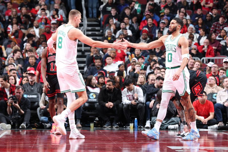 CHICAGO, IL - NOVEMBER 29: Kristaps Porzingis #8 high fives Jayson Tatum #0 of the Boston Celtics during the game against the Chicago Bulls  during the Emirates NBA Cup game on November 29, 2024 at United Center in Chicago, Illinois. NOTE TO USER: User expressly acknowledges and agrees that, by downloading and or using this photograph, User is consenting to the terms and conditions of the Getty Images License Agreement. Mandatory Copyright Notice: Copyright 2024 NBAE (Photo by Jeff Haynes/NBAE via Getty Images)