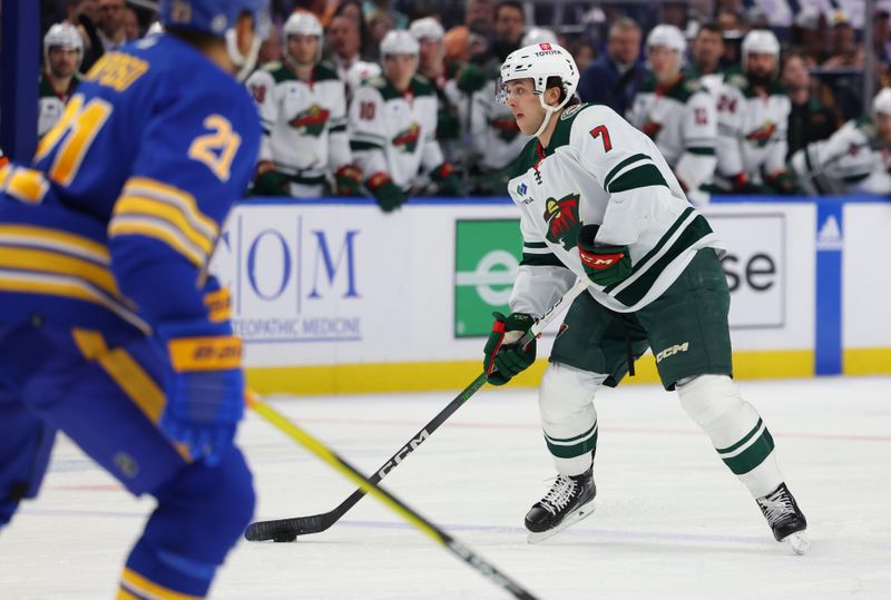 Nov 10, 2023; Buffalo, New York, USA;  Minnesota Wild defenseman Brock Faber (7) looks to make a pass during the first period against the Buffalo Sabres at KeyBank Center. Mandatory Credit: Timothy T. Ludwig-USA TODAY Sports