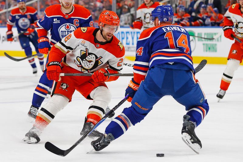 Jan 26, 2026; Edmonton, Alberta, CAN; Anaheim Ducks forward Jeff Viel (28) tries to move the puck past Edmonton Oilers defensemen Mattias Ekholm (14) during the second period at Rogers Place. Mandatory Credit: Perry Nelson-Imagn Images