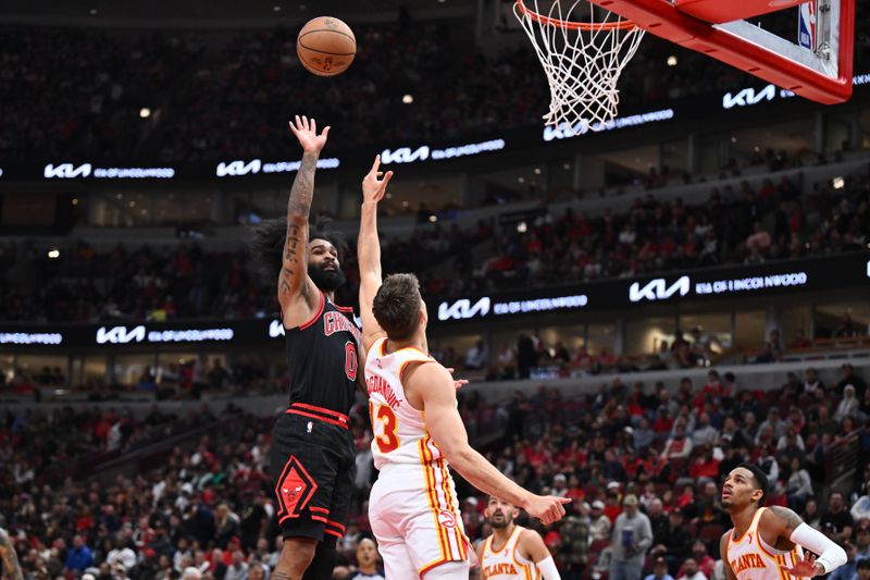 CHICAGO, ILLINOIS - APRIL 17:  Coby White #0 of the Chicago Bulls shoots the ball against Bogdan Bogdanovic #13 of the Atlanta Hawks in the second half during a play-in tournament game at United Center on April 17, 2024 in Chicago, Illinois. Chicago defeated Atlanta 131-116. NOTE TO USER: User expressly acknowledges and agrees that, by downloading and or using this photograph, User is consenting to the terms and conditions of the Getty Images License Agreement.  (Photo by Jamie Sabau/Getty Images)