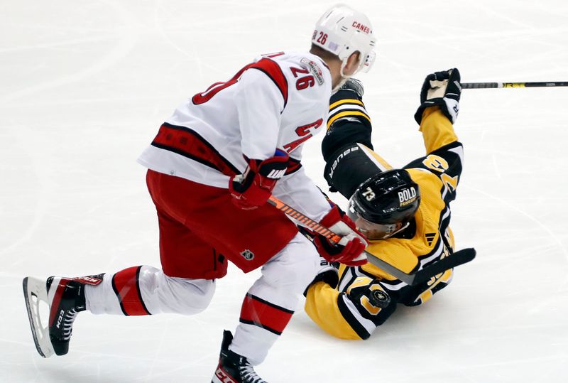 Nov 29, 2022; Pittsburgh, Pennsylvania, USA; Carolina Hurricanes center Paul Stastny (26) moves the puck against fallen Pittsburgh Penguins defenseman Pierre-Olivier Joseph (73) during the second period at PPG Paints Arena. Mandatory Credit: Charles LeClaire-USA TODAY Sports