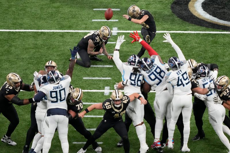 New Orleans Saints place-kicker Blake Grupe (19) kicks a 52-yard field goal as punter Lou Hedley (39) holds in the second half of an NFL football game against the Tennessee Titans in New Orleans, Sunday, Sept. 10, 2023. The Saints won 16-15. (AP Photo/Gerald Herbert)