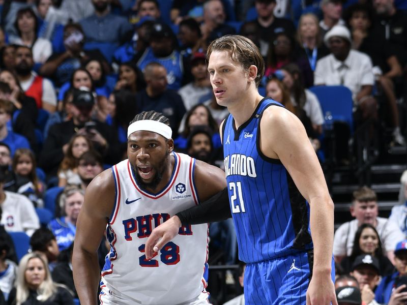 ORLANDO, FL - NOVEMBER 15: Guerschon Yabusele #28 of the Philadelphia 76ers and Joel Embiid #21 of the Philadelphia 76ers look on during the game during the Emirates NBA Cup game on  November 15, 2024 at Kia Center in Orlando, Florida. NOTE TO USER: User expressly acknowledges and agrees that, by downloading and or using this photograph, User is consenting to the terms and conditions of the Getty Images License Agreement. Mandatory Copyright Notice: Copyright 2024 NBAE (Photo by Fernando Medina/NBAE via Getty Images)