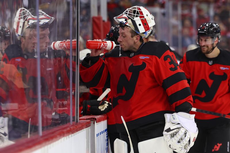 Mar 19, 2024; Newark, New Jersey, USA; New Jersey Devils goaltender Jake Allen (34) gets some water during a break against the Pittsburgh Penguins during the second period at Prudential Center. Mandatory Credit: Ed Mulholland-USA TODAY Sports