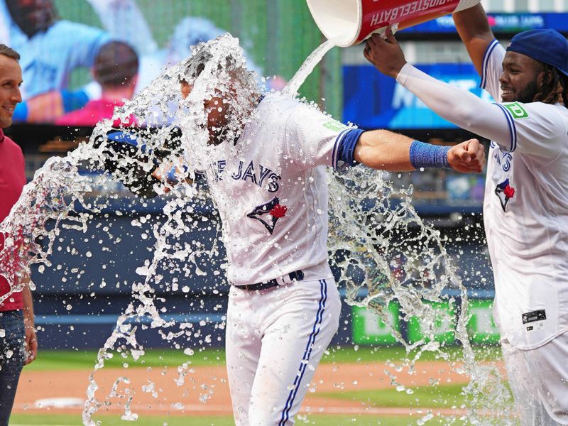 Jul 16, 2023; Toronto, Ontario, CAN; Toronto Blue Jays first baseman Vladimir Guerrero Jr. (27) pours the water bucket on center fielder Kevin Kiermaier (39) at the end of the ninth inning against the Arizona Diamondbacks at Rogers Centre. Mandatory Credit: Nick Turchiaro-USA TODAY Sports